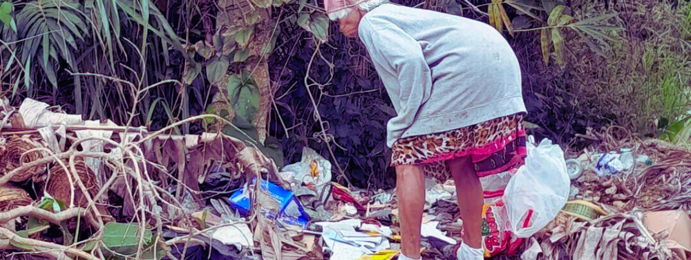 Vrouw zoekt tussen vuilnis